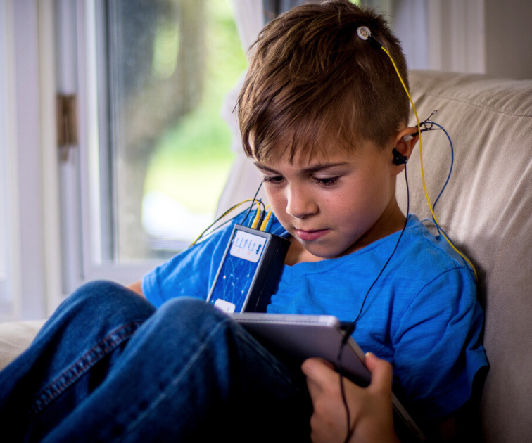 child reading while doing a neuroptimal neurofeedback session